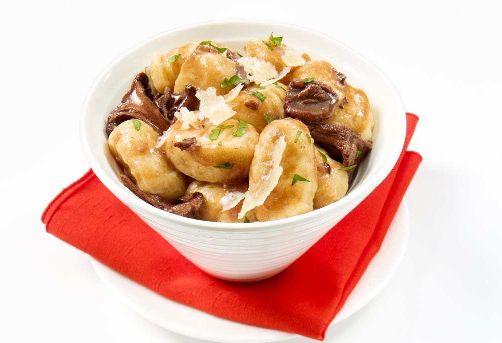 Gnocchis, sauce au vin rouge et champignons, garnis de Parmesan