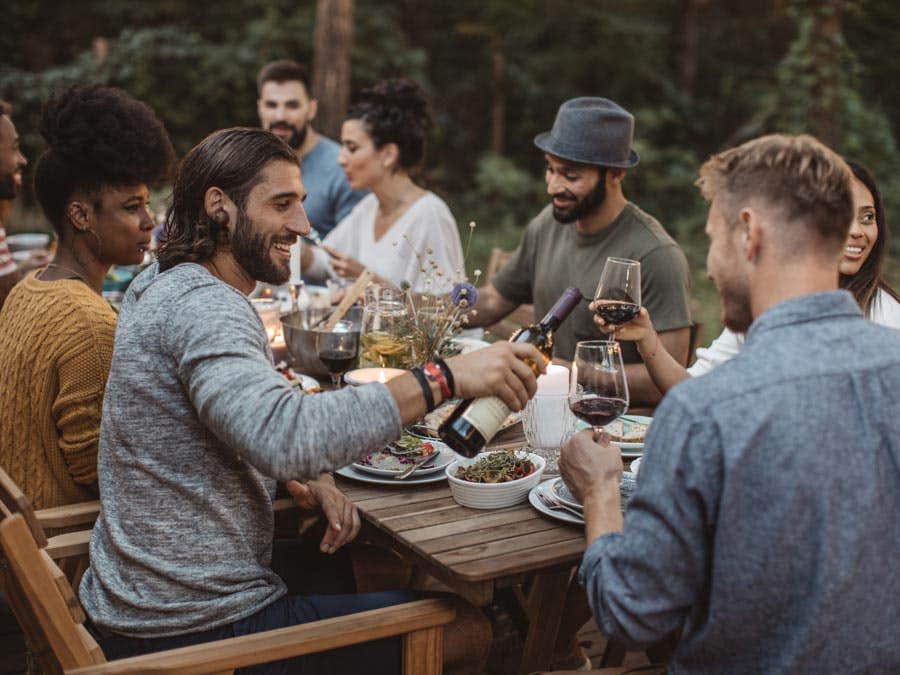 Friends drinking wine at dinner party