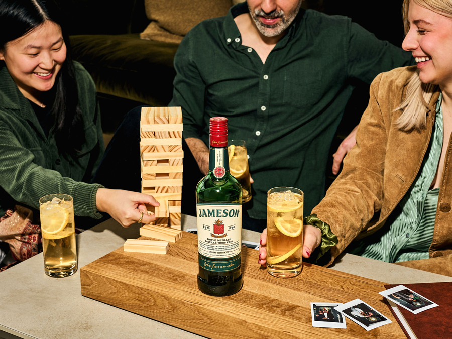 Group of friends playing blocks while drinking Jameson Whiskey