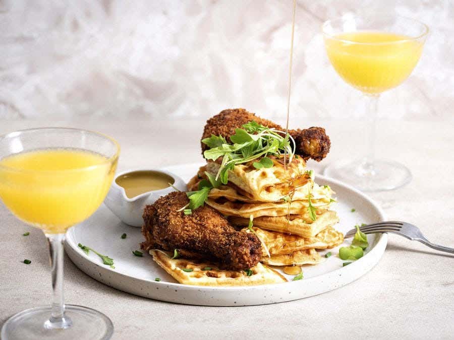 Gaufres avec poulet frit accompagnées d'un verre de mimosa