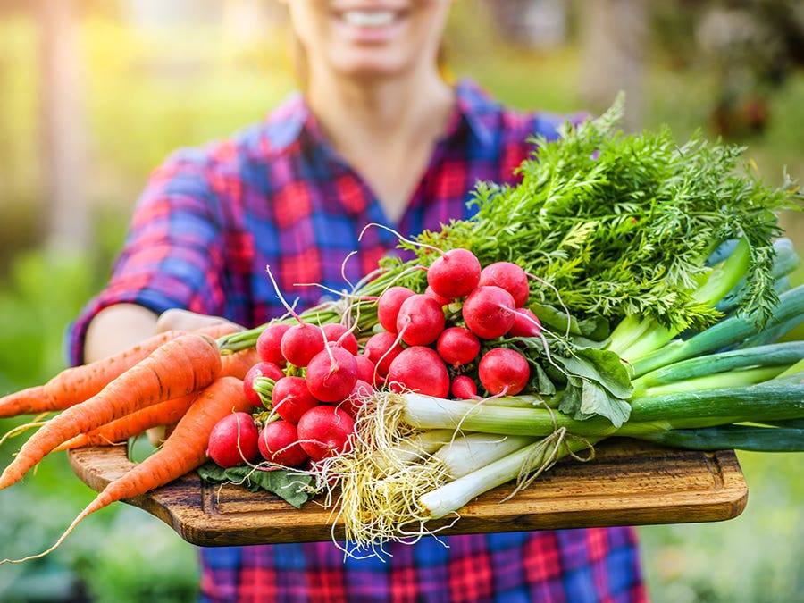 Woman holding a platter of fresh vegetables