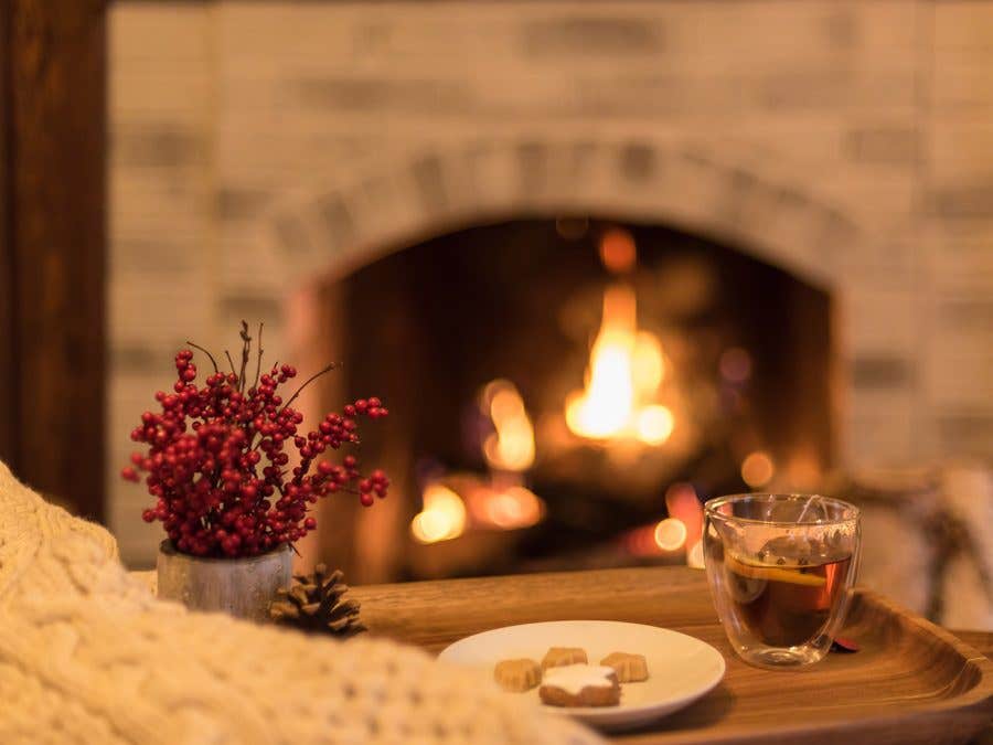 A glass of Winter Jack in front of a fireplace