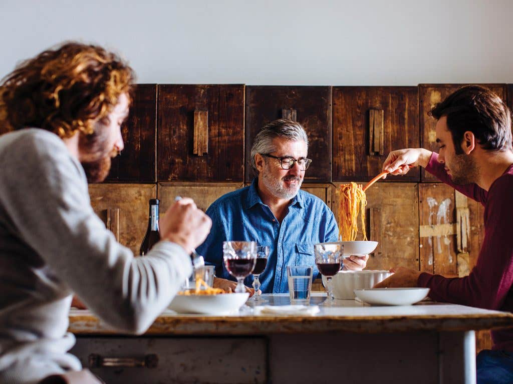 Personnes en train de savourer des spaghettis accompagnés de vin rouge