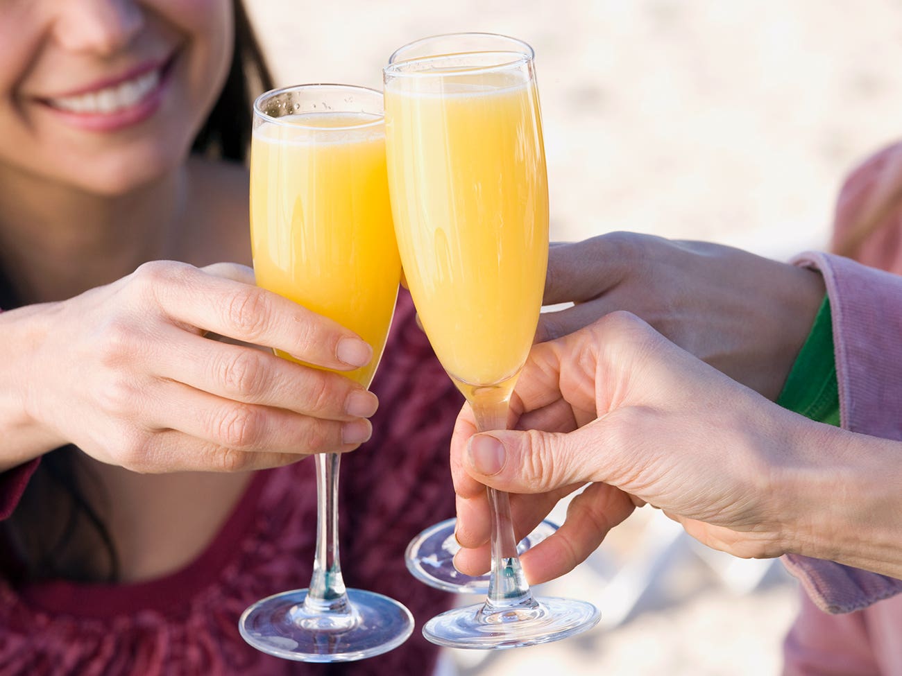 Personnes trinquant avec des verres de mimosa