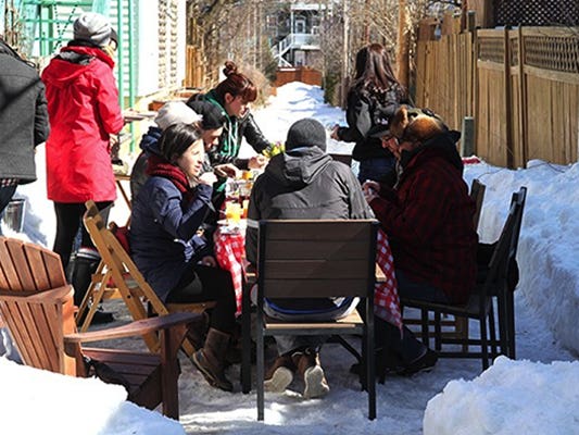 Personnes en train de savourer une repas à l'extérieur en hiver