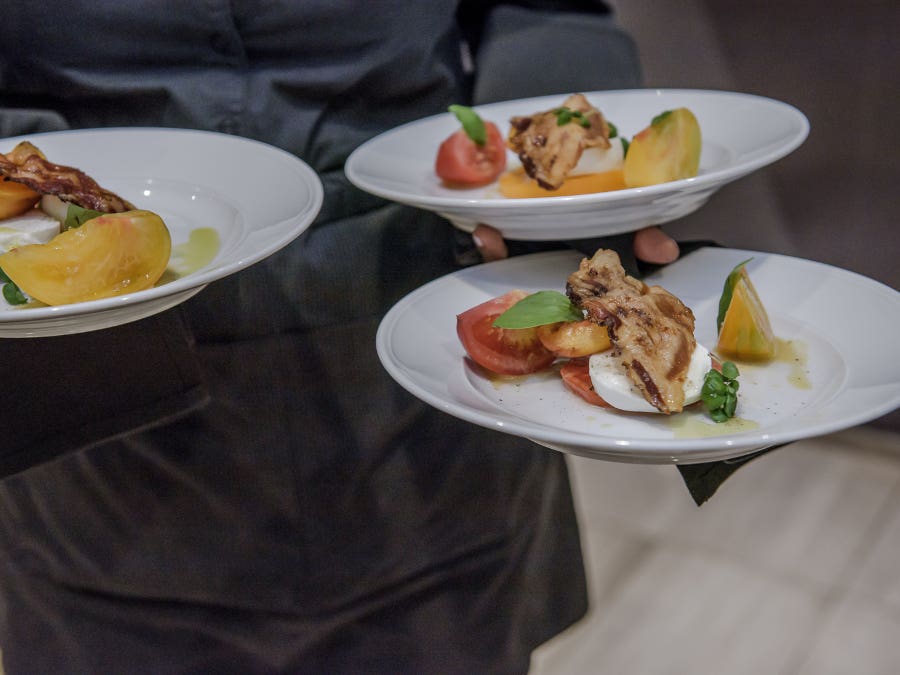 Personne transportant des assiettes pour un repas au restaurant